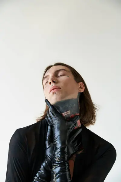 Vertical shot of alluring man in transparent shirt with hands in leather gloves on neck, fashion — Stock Photo