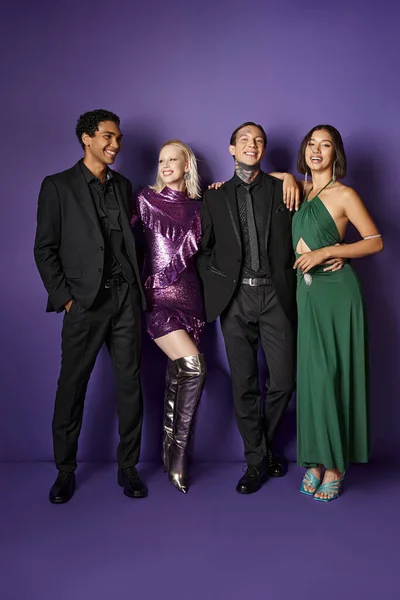 Neujahr 2024, gemischte männliche und weibliche Freunde in festlicher Kleidung, die sich vor violettem Hintergrund umarmen, Freude — Stockfoto