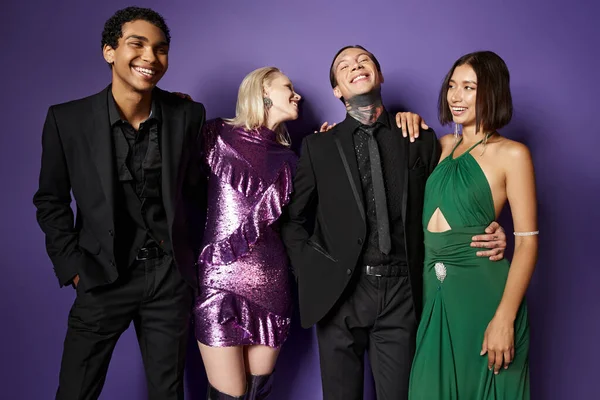 Nuevo año 2024, alegres amigos multiétnicos masculinos y femeninos en traje festivo abrazándose en púrpura - foto de stock