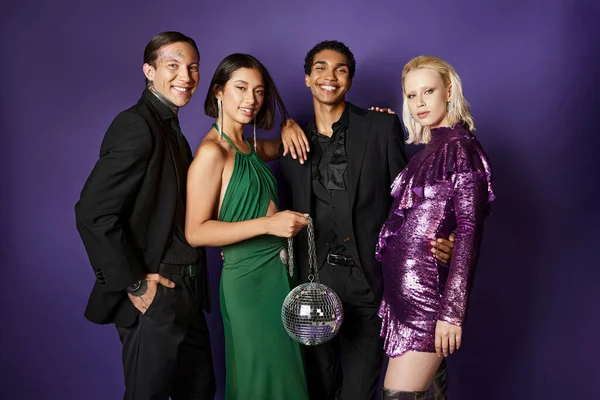 Año Nuevo 2024, grupo de alegres amigos interracial en trajes y vestidos de pie con bola disco - foto de stock