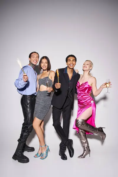 Four happy interracial friends holding champagne and sparkles while celebrating New year 2024 — Stock Photo