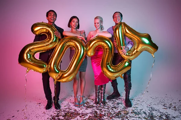 Fiesta de Año Nuevo, felices amigos interracial con atuendo festivo sosteniendo globos con números 2024 - foto de stock