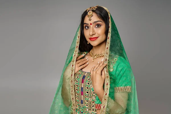 Красива індійська жінка з бінді на лобі в національному костюмі і зеленій вуаль дивиться на камеру — стокове фото