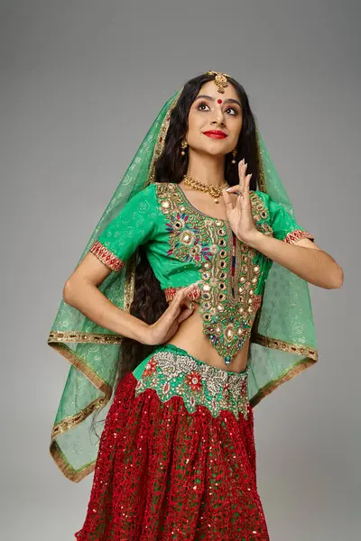 Tiro vertical de hermosa mujer india de pelo largo con gestos de puntos bindi y mirando hacia otro lado - foto de stock