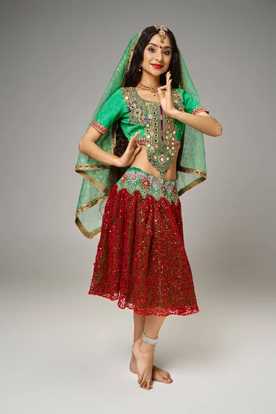 Веселая красивая индийская женщина в традиционном чоли и юбке жестикулирует и смотрит в камеру — стоковое фото