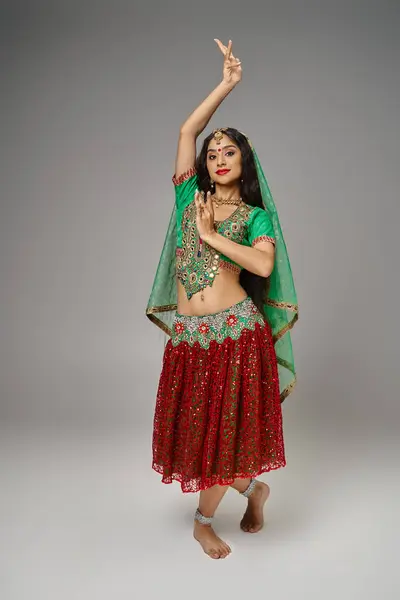 Plan vertical de jolie femme indienne aux cheveux longs et bindi dansant vif et regardant la caméra — Photo de stock