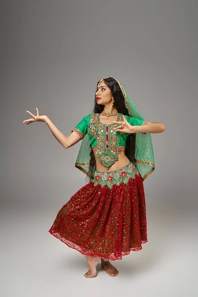 Plan vertical de la femme attirante indienne en vêtements traditionnels gesticulant tout en dansant activement — Photo de stock