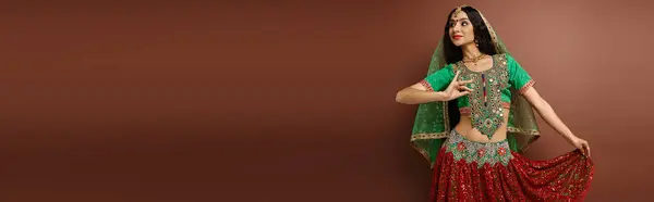 Hermosa mujer india con punto bindi en traje tradicional gesto mientras baila animado, bandera - foto de stock