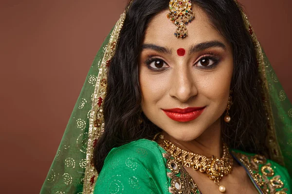 Портрет привлекательной индийской женщины с традиционными аксессуарами и точкой бинди, смотрящей в камеру — стоковое фото