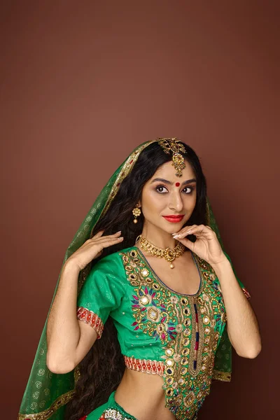 Вертикальный снимок привлекательной индийской женщины в зеленом традиционном чоли с бинди и аксессуарами — стоковое фото