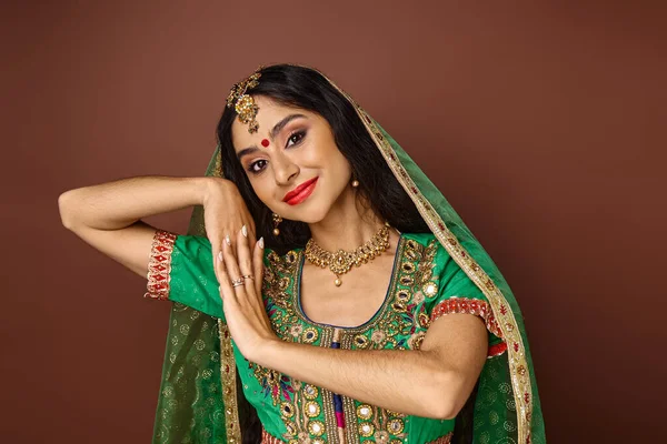 Красивая молодая индианка с бинди точка в национальной одежде жестом и счастливо улыбается в камеру — стоковое фото