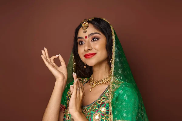 Attractive indian woman in national costume with bindi and green veil gesturing and looking away — Stock Photo