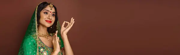 Schöne Indianerin in Nationaltracht mit Bindi und grünem Schleier, die lebhaft gestikuliert, Banner — Stockfoto