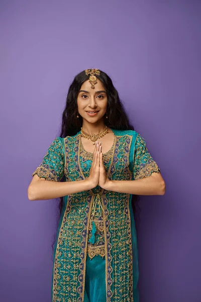 Joyous young indian woman in national costume showing praying gesture and looking at camera — Stock Photo