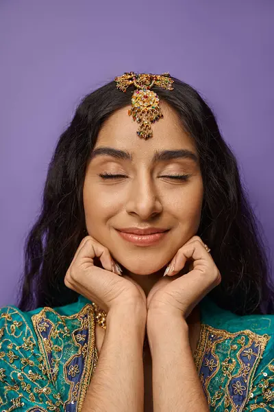 Vertikale Aufnahme einer attraktiven Indianerin in Nationaltracht mit geschlossenen Augen und Händen unter dem Kinn — Stockfoto