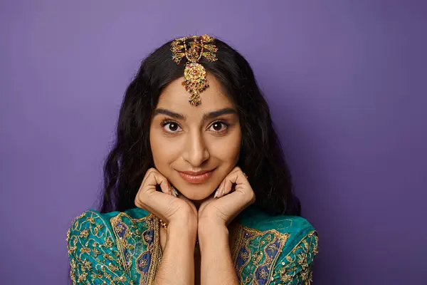 Attraktive junge indische Frau in traditioneller Kleidung posiert mit den Händen unterm Kinn und blickt in die Kamera — Stockfoto