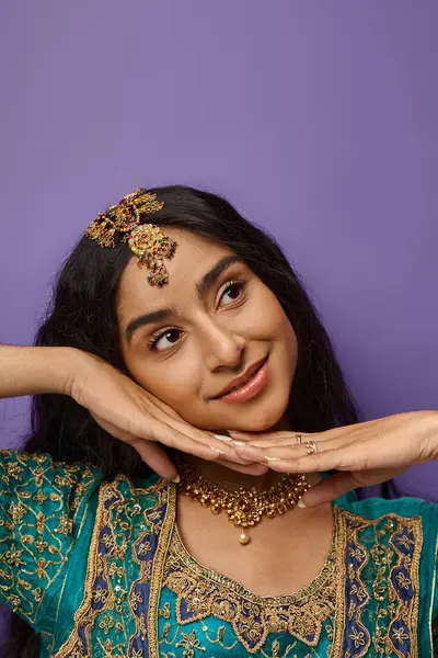 Tiro vertical de bela mulher indiana alegre posando com as mãos sob o queixo e olhando para longe — Fotografia de Stock