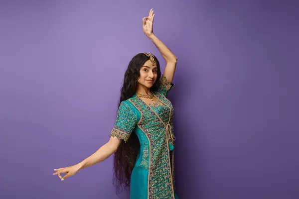 Atractiva mujer india en sari tradicional gesto mientras baila y sonríe alegremente a la cámara - foto de stock