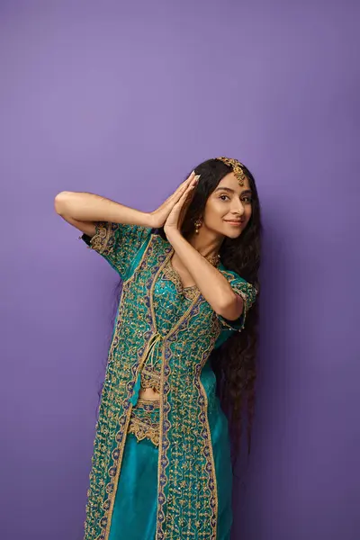 Beautiful indian woman with long hair in national clothes posing in motion and looking at camera — Stock Photo
