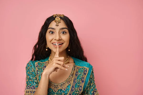 Jovem mulher indiana alegre em traje tradicional mostrando gesto de silêncio e olhando para a câmera — Fotografia de Stock