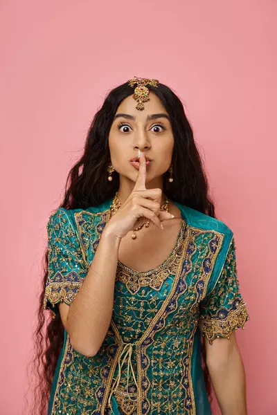 Vertical shot of young pretty indian woman in blue sari showing silence gesture looking at camera — Stock Photo