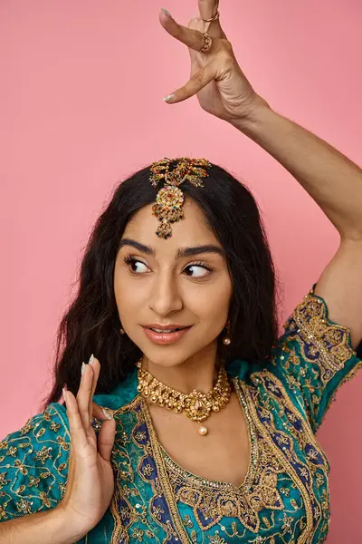 Attractive jolly young indian woman in national costume gesturing while dancing and looking away — Stock Photo