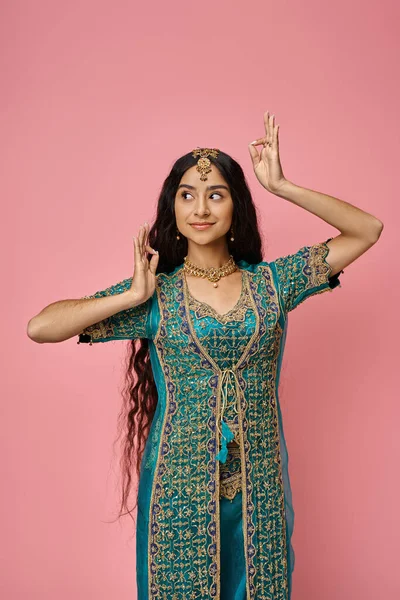 Plan vertical de la jeune femme indienne dans les vêtements traditionnels avec des accessoires gesticulant activement — Photo de stock