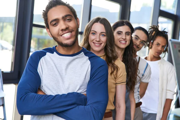 Portrait of smiling african american man with folded arms near creative team, confident leadership — Stock Photo