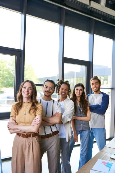 Successful multiethnic colleagues in stylish casual attire standing with folded arms in office — Stock Photo