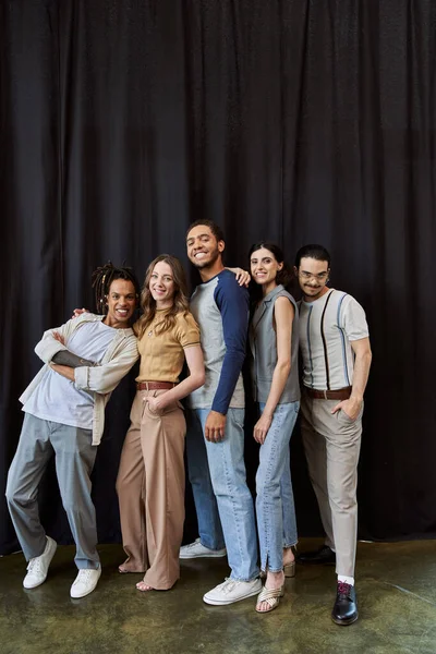 Joyful multiethnic startup team posing on black backdrop in modern coworking office, group portrait — стоковое фото