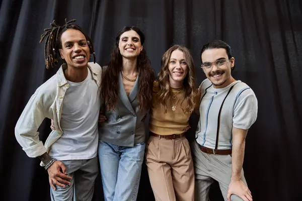 Group portrait of glad multiethnic team smiling at camera on black backdrop in modern office — Stock Photo
