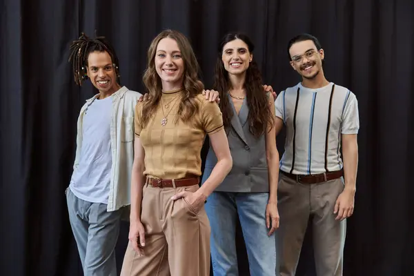 Foto de grupo de equipe de negócios multicultural elegante sorrindo para a câmera perto de cortinas pretas no escritório — Fotografia de Stock
