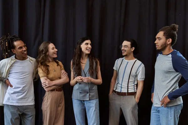 Felici colleghi multiculturali che si sorridono a vicenda vicino a drappeggio nero in ufficio, foto di gruppo — Foto stock