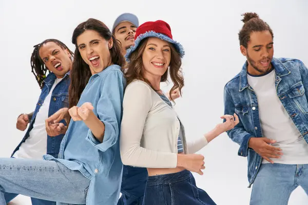 Alegre multicultural amigos en moda casual desgaste divertirse y bailar en gris telón de fondo — Stock Photo