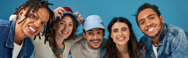 Group portrait of cheerful multicultural friends in trendy casual attire on blue backdrop, banner — стоковое фото