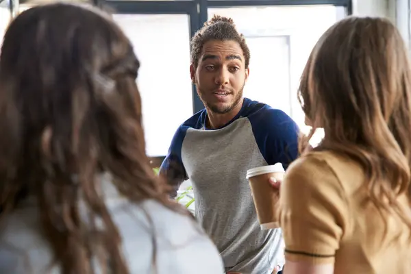 Excited african american man talking and sharing ideas with female colleagues in office, teamwork — Stock Photo