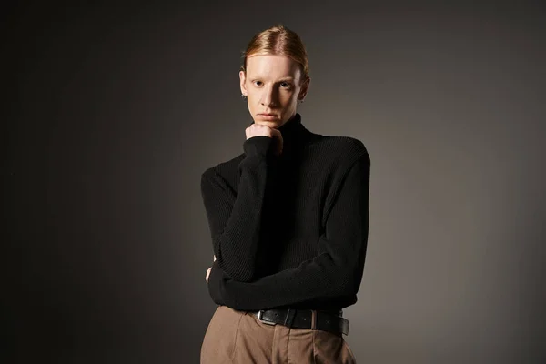 Good looking non binary person looking straight at camera with fist under chin, fashion concept — Stock Photo