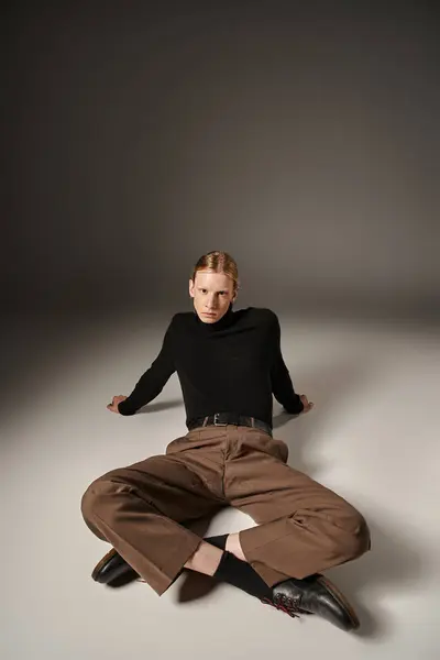 Good looking stylish non binary person with red hair and ponytail lying on floor, fashion — Stock Photo