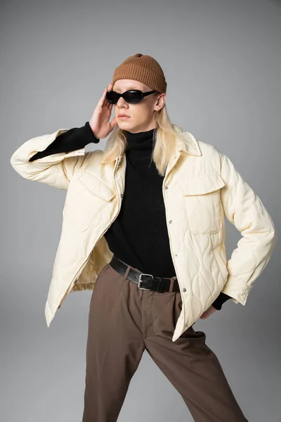 Vertical shot of young good looking non binary person in stylish outfit posing and looking away — Stock Photo