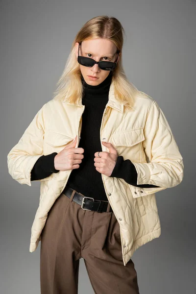 Plano vertical de joven atractivo andrógino persona en invierno traje de moda mirando a la cámara - foto de stock