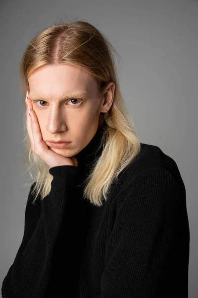 Young handsome non binary model in black trendy turtleneck posing with hand on face, fashion — Stock Photo