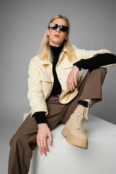 Вертикальный снимок стильного андрогинного человека в зимней куртке и модных солнцезащитных очках, концепция моды — стоковое фото