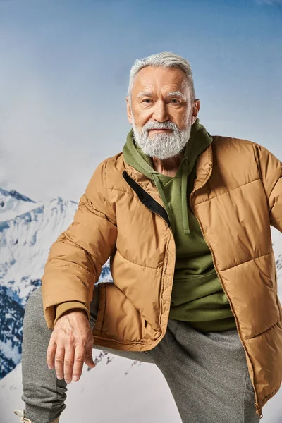 Porträt eines sportlich gekleideten Mannes mit erhobenem Knie, der in die Kamera blickt, Winterkonzept — Stockfoto