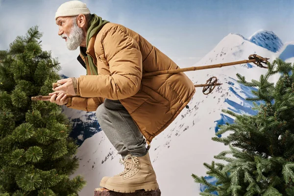 Sporty bearded man dressed like Santa squatting with ski poles posing in profile, winter concept — Stock Photo