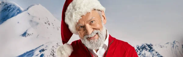 Веселий білий бородатий Санта, посміхаючись на камеру з засніженим гірським тлом, зимова концепція, банер — стокове фото
