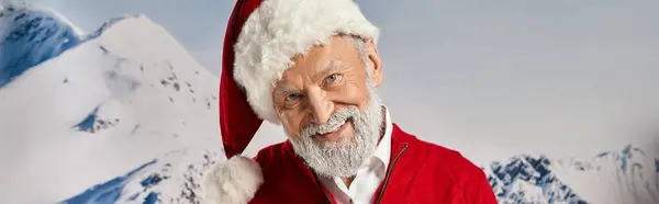 Alegre barbudo blanco Santa sonriendo a la cámara con fondo de montaña nevada, concepto de invierno, bandera - foto de stock