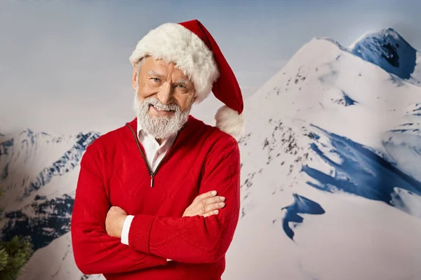 Hombre alegre en traje de Santa sonriendo a la cámara con los brazos cruzados en el pecho, concepto de invierno - foto de stock