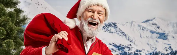 Alegre barbudo blanco Santa con bolsa de regalo sonriendo alegremente a la cámara, concepto de invierno, bandera - foto de stock