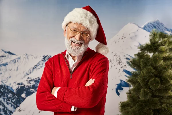 Радостный Санта в рождественской шляпе с очками со скрещенными руками на груди, счастливого Рождества — стоковое фото