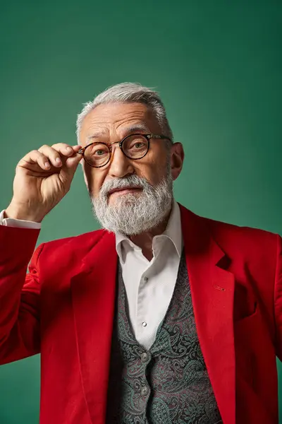 Porträt des edlen, gutaussehenden Weihnachtsmannes, der seine Brille berührt und in die Kamera blickt, Winterkonzept — Stockfoto